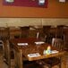 A room with walnut American Tables & Seating chairs and tables.