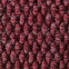 A close up of a burgundy carpet with a textured pattern.