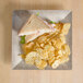 A Thunder Group Jazz melamine plate with a sandwich and chips on a table.