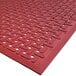 A red Cactus Mat commercial floor mat with holes in it.