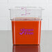 A Cambro CamSquares clear polycarbonate food storage container with red liquid inside on a counter.