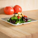 A Thunder Group Jazz melamine plate with salad on a table.