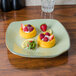 A Tuxton Artisan china pasta plate with a lemon and strawberries on it.