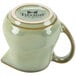 A Tuxton Artisan Sagebrush creamer with a lid on it.