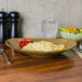 A TuxTrendz Mojave ellipse china plate with rice and vegetables on a table with a fork and knife.
