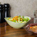 A Tuxton Capistrano bowl filled with salad and a bowl of soup on a table.