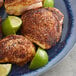 A plate of food with chipotle seasoned chicken and lime wedges.