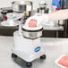 A person using a Globe hamburger press to make a patty.
