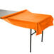 A Sunkissed Orange plastic table cover on a table.