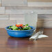 A Fiesta Lapis blue china bowl filled with salad on a table.