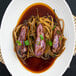 A plate of noodles and mushrooms with Kikkoman soy sauce on a table.