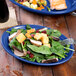 A Fiesta Lapis oval china platter with a salad and a fork on it.