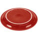 A red Fiesta Healthcare china plate with a white rim.