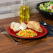 A Scarlet Fiesta healthcare china plate with food on a table.