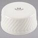 A white round Tuxton china ramekin with a wavy design.