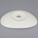 A white Tuxton china plate with a black ellipse logo.