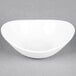 A Tuxton porcelain white Capistrano bowl on a grey surface.