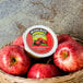 A basket of apples with a container of Musselman's Unsweetened Applesauce.