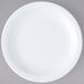 A white Carlisle bread and butter plate with a white rim on a gray surface.