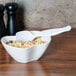 A bowl of pasta with a white plastic Fineline Serving Spoon in it.