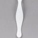 A close up of a Fineline white plastic serving fork.