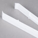 A pair of white plastic Fineline serving tongs.