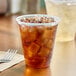 A Dart ClearPro plastic cup with a drink in it and ice on a table.