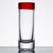 A close up of a Libbey shot glass with a red rim.