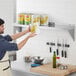 A man holding a can of food on a Regency stainless steel wall shelf.