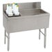 A stainless steel Advance Tabco ice bin and bottle storage combo unit with white containers on top.