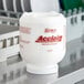A white container of Noble Acclaim concentrated solid dish machine detergent.