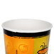 A white paper cup with a black and orange Streetside print.