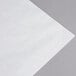 Wet wax paper for sandwiches on a gray surface.
