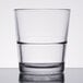 A close up of a Libbey stackable rocks glass filled with water on a table.