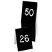 A stack of black Cal-Mil table tents with white numbers on them.