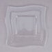 A clear plastic lid with a wavy edge on a square bowl.
