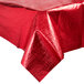 A red metallic Creative Converting plastic table cover on a table with a white background.