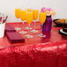 A table with a red table cloth and a plate of food.