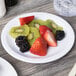 A Carlisle white melamine pie plate with a slice of fruit pie on it.