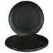 An Elite Global Solutions black melamine plate on a table with two more plates.