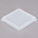 A clear square plastic lid on a white square plastic container.