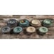 A stack of six Elite Global Solutions round crackle bowls on a wood table.