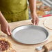 An aluminum pie pan measuring 11 7/8 inches in diameter and 7/8 inch deep.