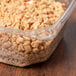 A 12 oz square recycled PET deli container filled with food on a counter.
