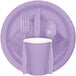 A purple paper plate with a fork, spoon, and knife on a purple dinner napkin.