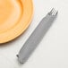 A fork and knife in a Shimmering Silver 3-ply paper dinner napkin.