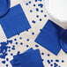 A table set with a blue Creative Converting luncheon napkin and confetti.