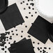 A table with black napkins and confetti.