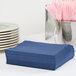A stack of navy blue Creative Converting luncheon napkins.