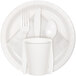 A white plate with a white Creative Converting luncheon napkin, plastic cup, spoon, and fork on it.